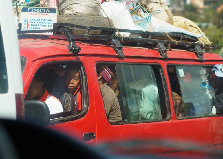überfüllter roter Bus steckt im Verkehr fest