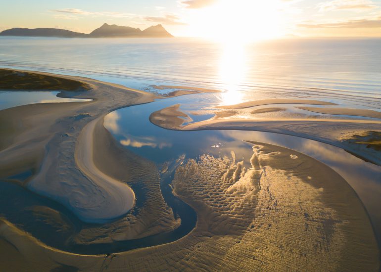 Luftaufnahme eines Strandes in Neuseeland bei Sonnenuntergang