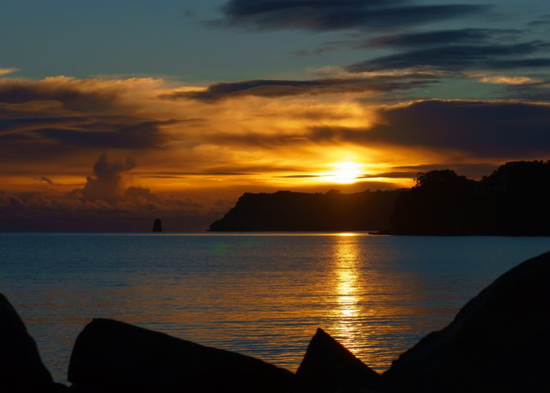 Sonnenuntergang an felsiger Küste in Neuseeland