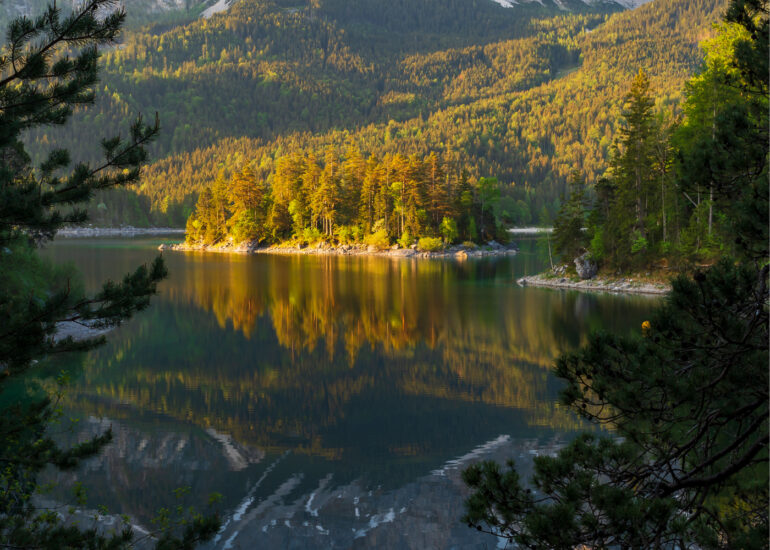 Blick auf den Eibsee mit Insel in der Mitte und Zugspitze im Hintergrund zum Sonnenaufgang