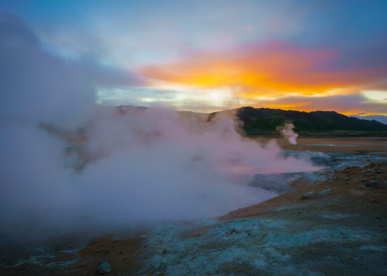 Rot leuchtender Himmel mit heißen Dampfwolken im Vordergrund