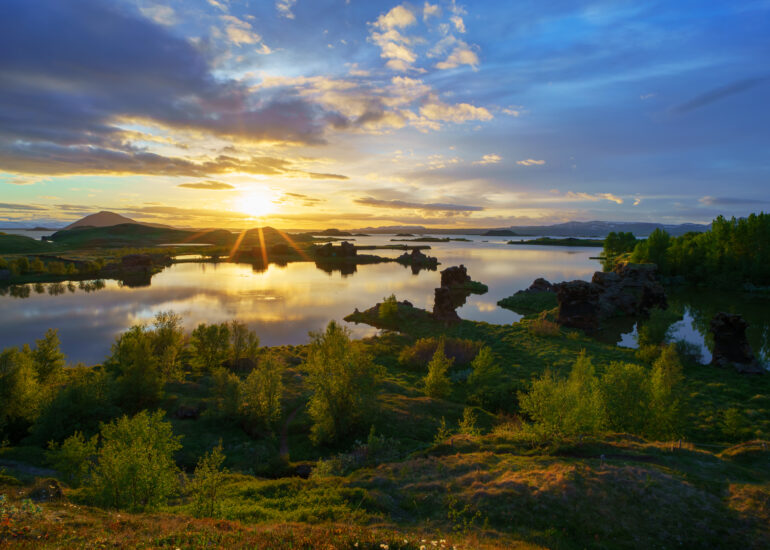 Sonnenuntergang am Mývatn mit erkalteter Lava und grüner Landschaft