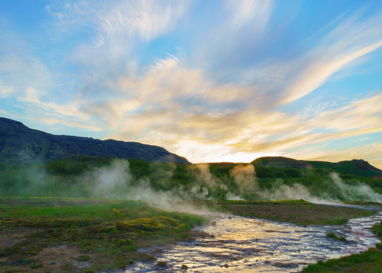 Sonnenuntergang mit leuchtenden Wolken und heißen Dämpfen aus der Erde