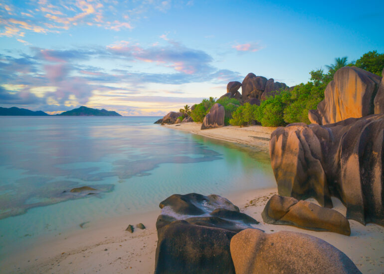 Sonntenuntergang am Strand Anse Source d'Argent mit klarem Wasser und leuchtenden Granitfelsen